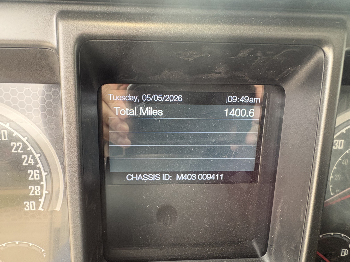 Vehicle dashboard display showing total miles 1400.6 and chassis ID M403009411 on Mack GR84F dump truck interior