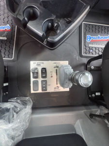 Mack GR84F truck interior control panel with joystick lever and multiple switches visible in the cab area.