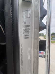 Truck door jamb label with vehicle specifications: VIN 1M2GR3NC3VM009411, weights and tire info, and other compliance text. Visible text arranged in multiple lines.