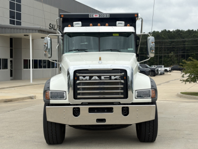Dump truck front view of a white 2027 Mack GR84F showing grille with 'MACk' emblem and bumper, with large mirrors and roof light bar.