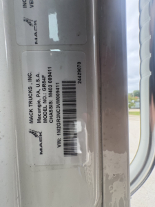 Labeled information on a Mack Trucks component showing VIN and model details; visible text includes MACK TRUCKS INC, MADE IN USA, MODEL GR84B? and VIN 1M2GR3NC3VM009411 along with a barcode and stock number 72321.