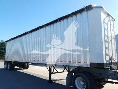 Trailer side view showing a Dorsey open top chip van with elevated rear and tandem axles.