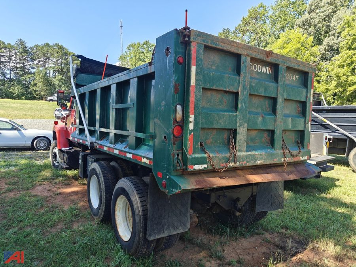 Dump truck bed of a Ford LT8000 in dual rear wheels showing back with tailgate and hydraulic dump mechanism.