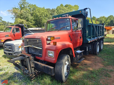 Ford LT8000 dump truck in red with front plow, dump bed, and Goirav? lettering; dual rear axles; image shows a heavy-duty work truck with a hydraulic dump bed.