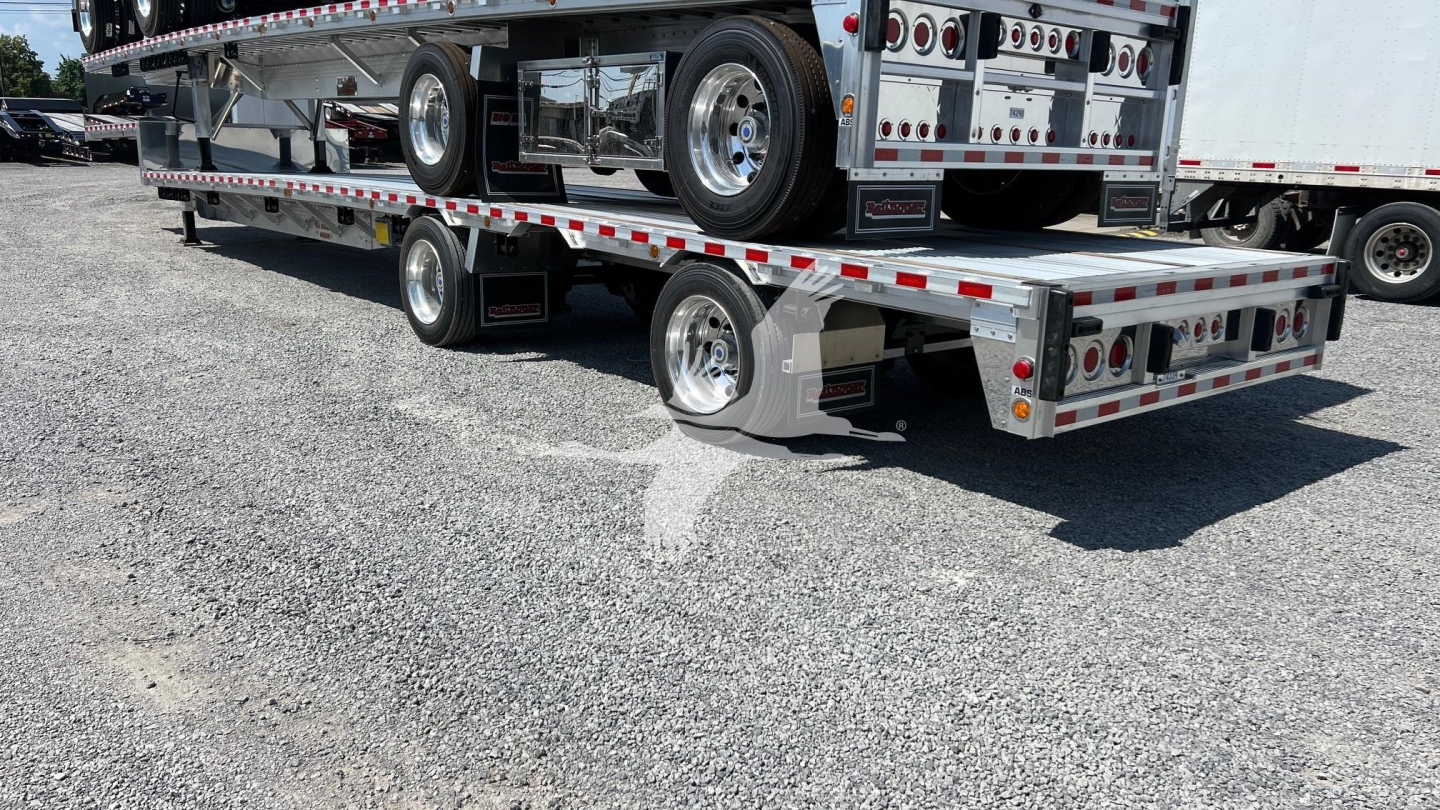 Trailer deck showing a Reitnouer Big Bubba dropdeck trailer with aluminum flooring and rear steps.