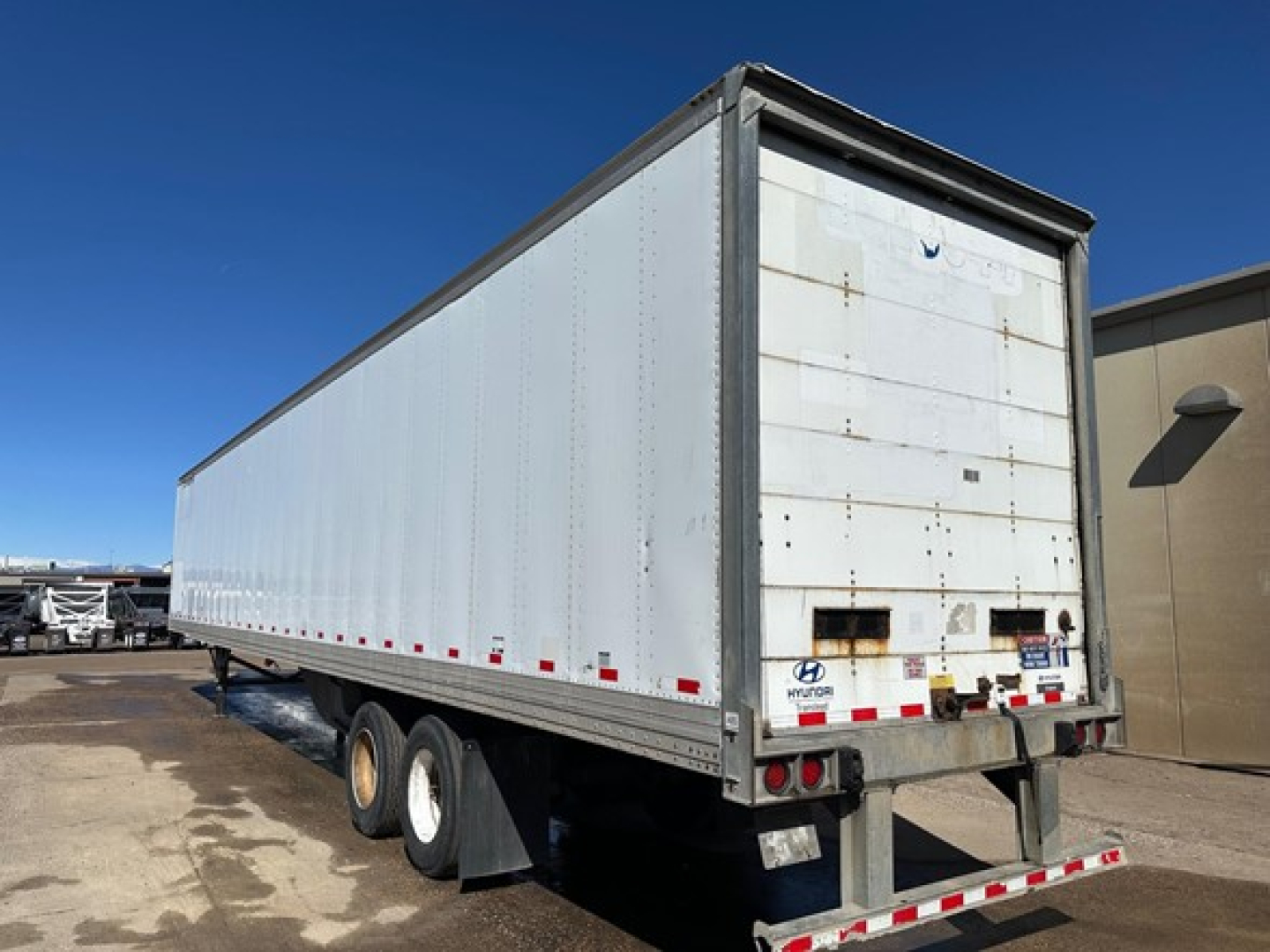 Trailer rear and side view of a 2015 Hyundai air ride dry van with white box, dual rear axles, and rear underrun bar.