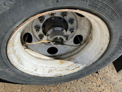 Wheel and rim of a used 2015 Hyundai air ride dry van trailer showing a white steel wheel with rust spots and tire tread.