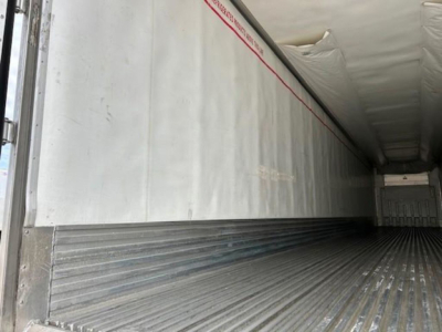 Refrigerated trailer interior with metal ribbed floor and insulated walls, seen from the side doorway in a 2019 Utility Reefer.