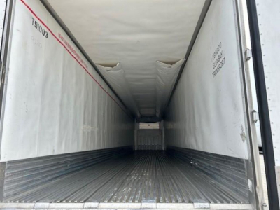 Trailer interior showing empty refrigerated cargo area with ribbed floor and white interior walls.
