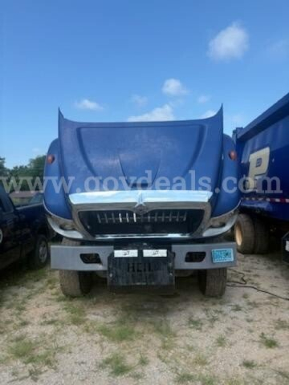 Front view of 2011 International 7500 truck with blue hood open showing grille and bumper area.