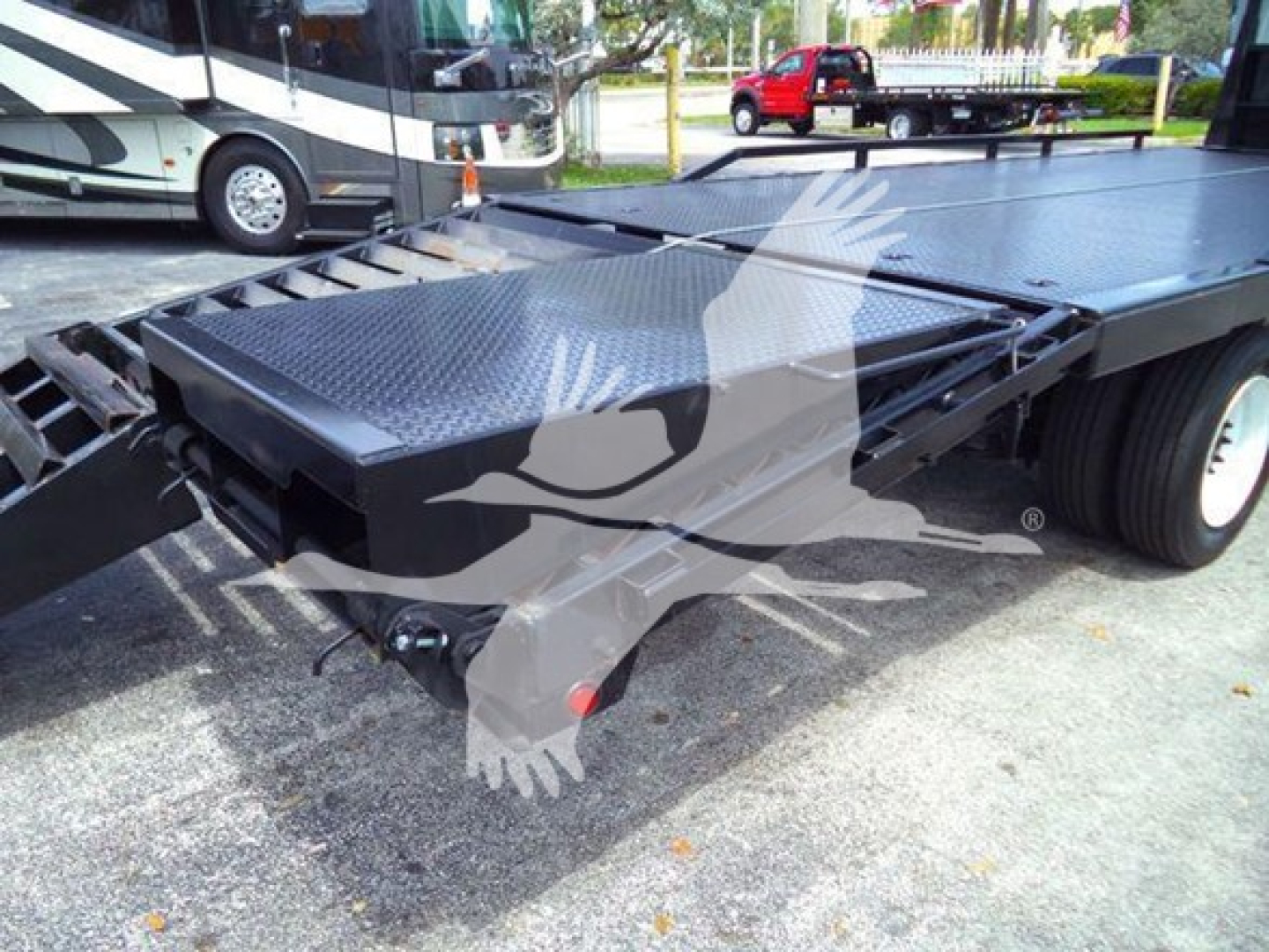 Flatbed truck bed of a 2012 Freightliner Business Class M2 106 showing diamond plate steel ramp/bed surface and hitch area.