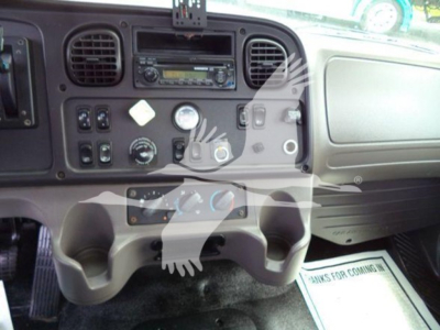 Dashboard and center console of Freightliner Business Class M2 106 with gauges, controls, and cup holders visible