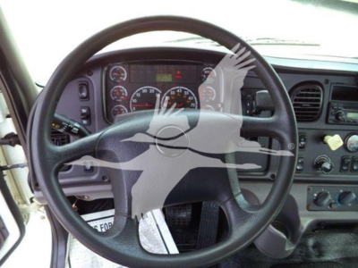 Steering wheel and dashboard of a Freightliner Business Class M2 106 cab showing gauges and controls.