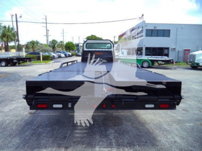 Back of a flatbed truck on a Freightliner Business Class M2 106, with a dual rear bumper and taillights visible.