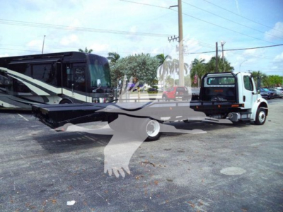Flatbed tow vehicle showing Freightliner Business Class M2 106 chassis with a long flatbed and two units in a lot.