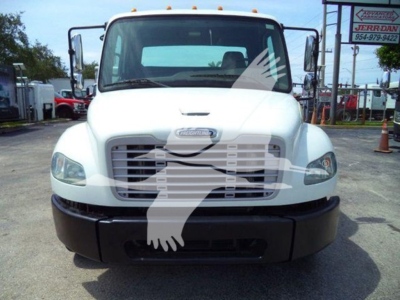 Front view of a 2012 Freightliner Business Class M2 106 flatbed truck showing grille and bumper, with headlights and windshield visible.