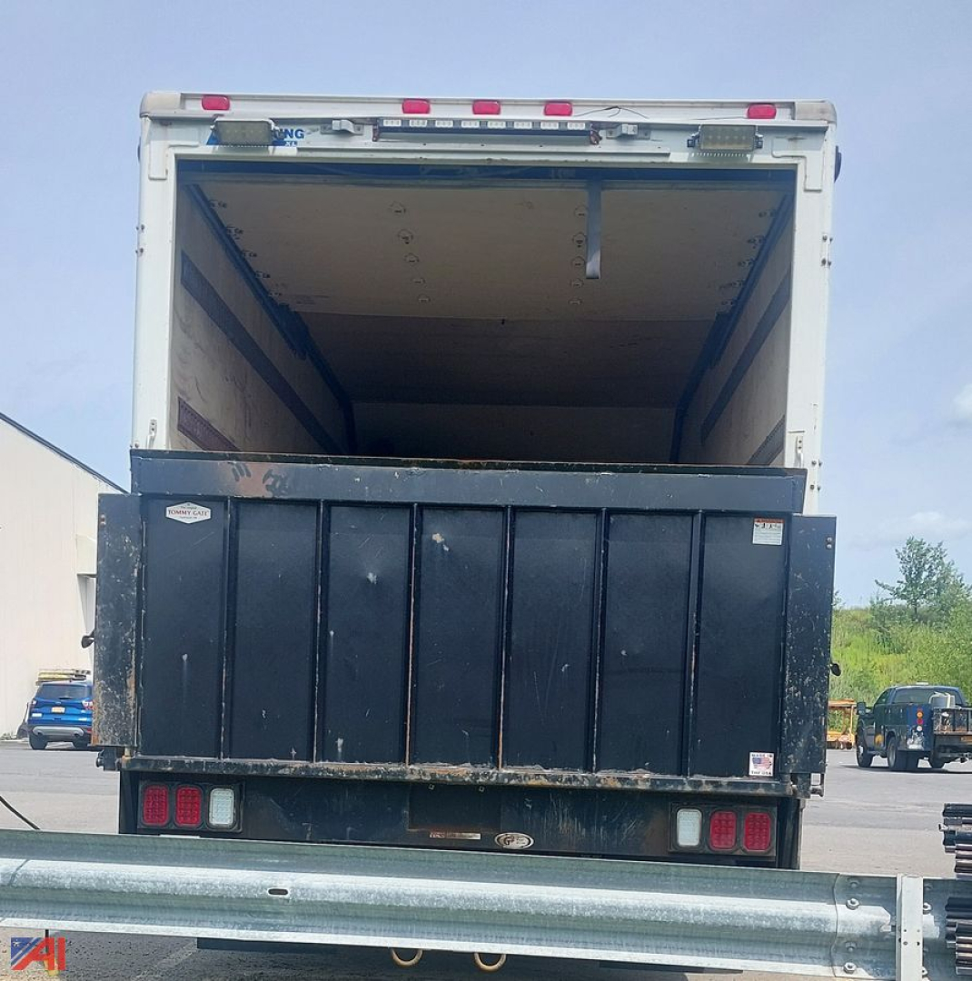 Box truck rear showing empty cargo area and black rear gate with tail lights.