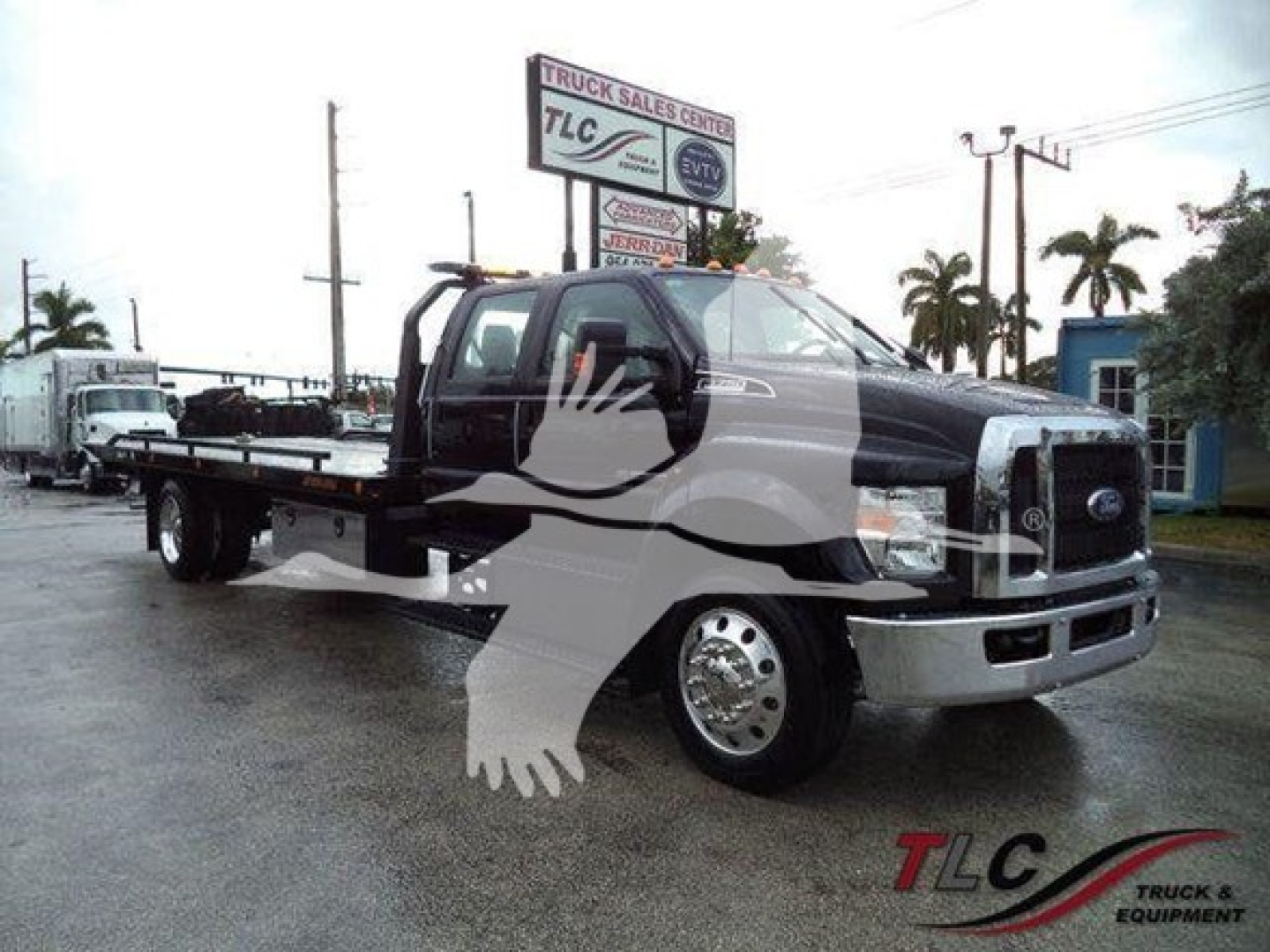 Ford F-750 rollback truck in service body with tow equipment and mirror image watermark.