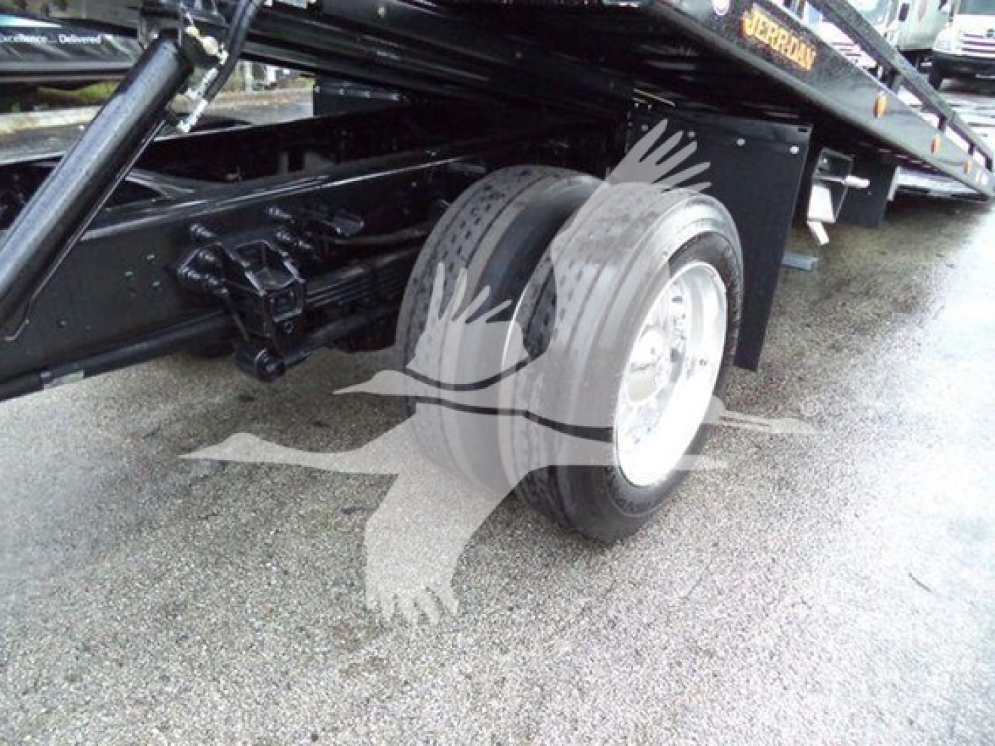 Ford F750 rollback chassis showing dual rear wheels and suspension components.