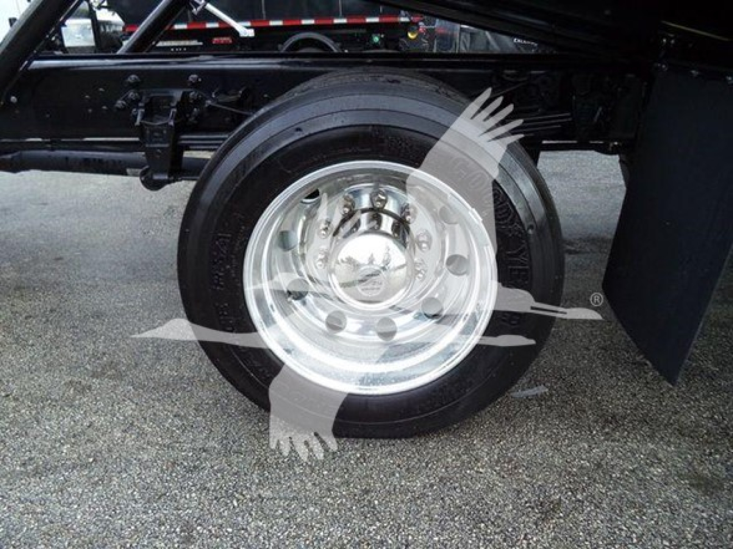 Ford F750 rollback truck wheel and suspension showing front tire with polished aluminum wheel and black frame