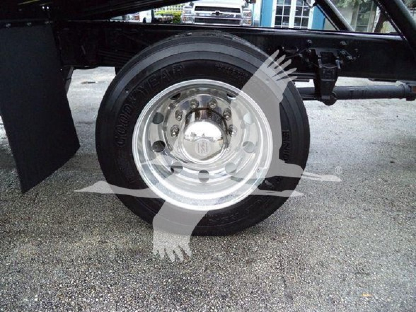 Wheel and tire on Ford F750 rollback truck with chrome hubcap and black tire sidewall; partial undercarriage visible.