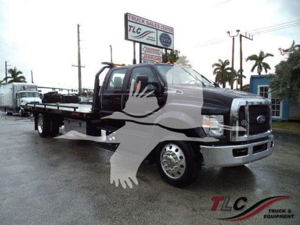 Ford F-750 rollback truck in service body with tow equipment and mirror image watermark.