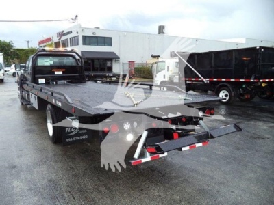 Flatbed tow truck rear view showing equipment and reflective chevrons.