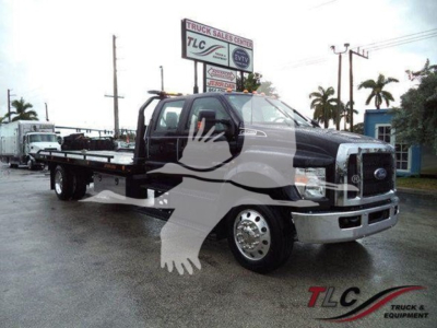 Ford F-750 rollback truck in service body with tow equipment and mirror image watermark.