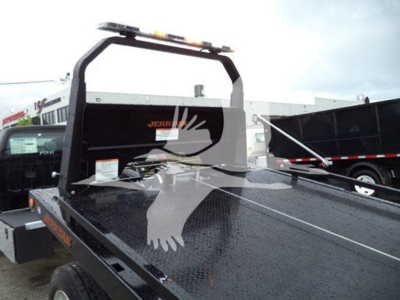 Ford F750 rollback truck bed in-service showing diamond plate steel bed and rear cab roll bar with lights.
