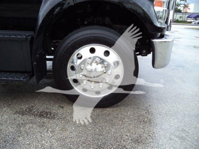 Ford F-750 rollback truck front wheel and hubcap; visible tire markings and chrome wheel.
