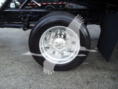 Ford F750 rollback truck wheel and suspension showing front tire with polished aluminum wheel and black frame