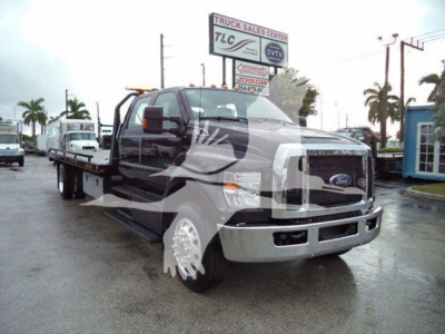 Ford F-750 tow truck chassis in front view showing extended flatbed and chrome grille.