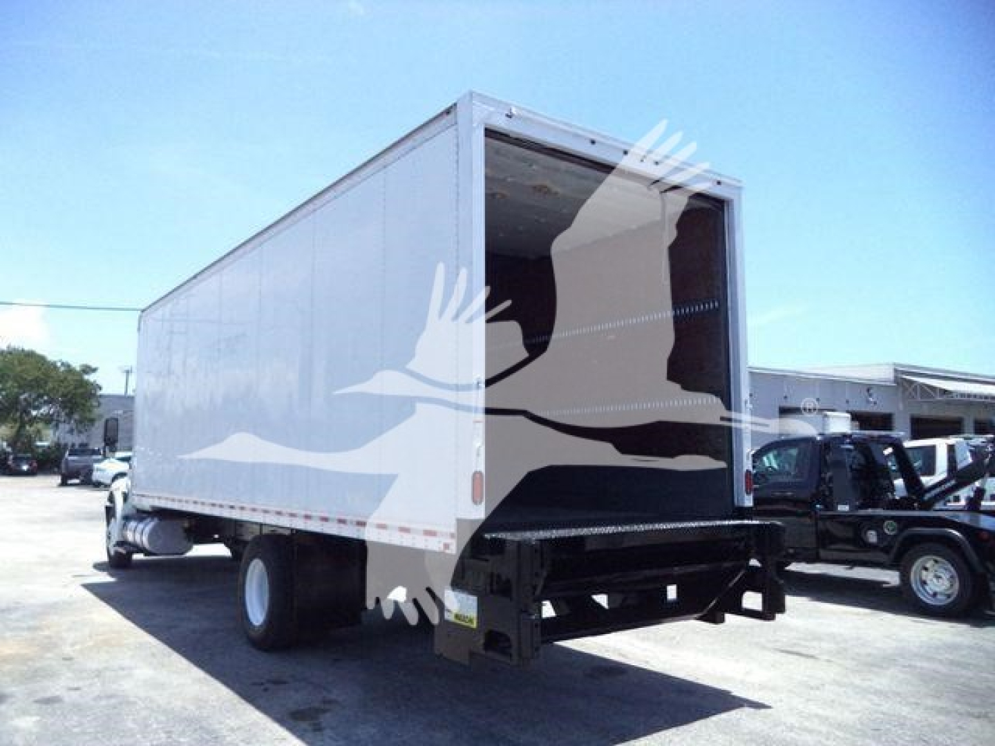Box truck from rear-left view showing cargo area and open ramp, 2019 International Durastar 4300.