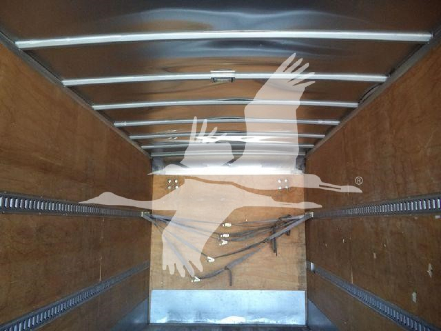 Interior of box truck cargo area showing wooden walls and metal rails along the ceiling.