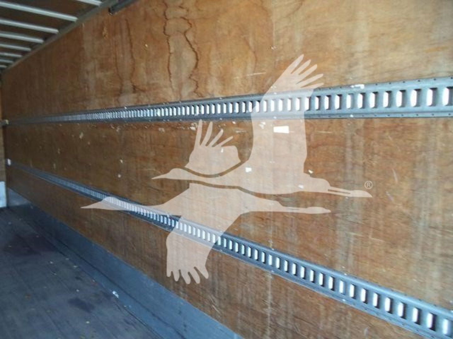 Inside cargo area of a 2019 International Durastar 4300 box truck showing wooden side panels and metal cargo rails.