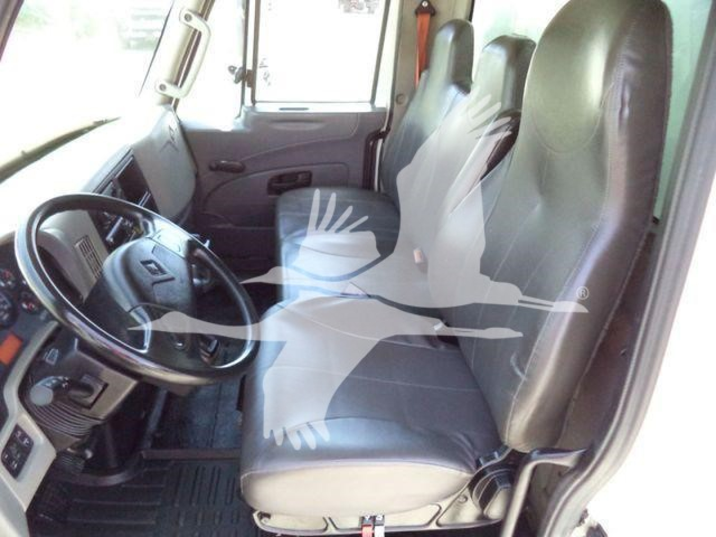 Cab interior of a 2019 International Durastar 4300 box truck showing left-hand drive, bench seating with two front seats and steering wheel, simple dashboard.