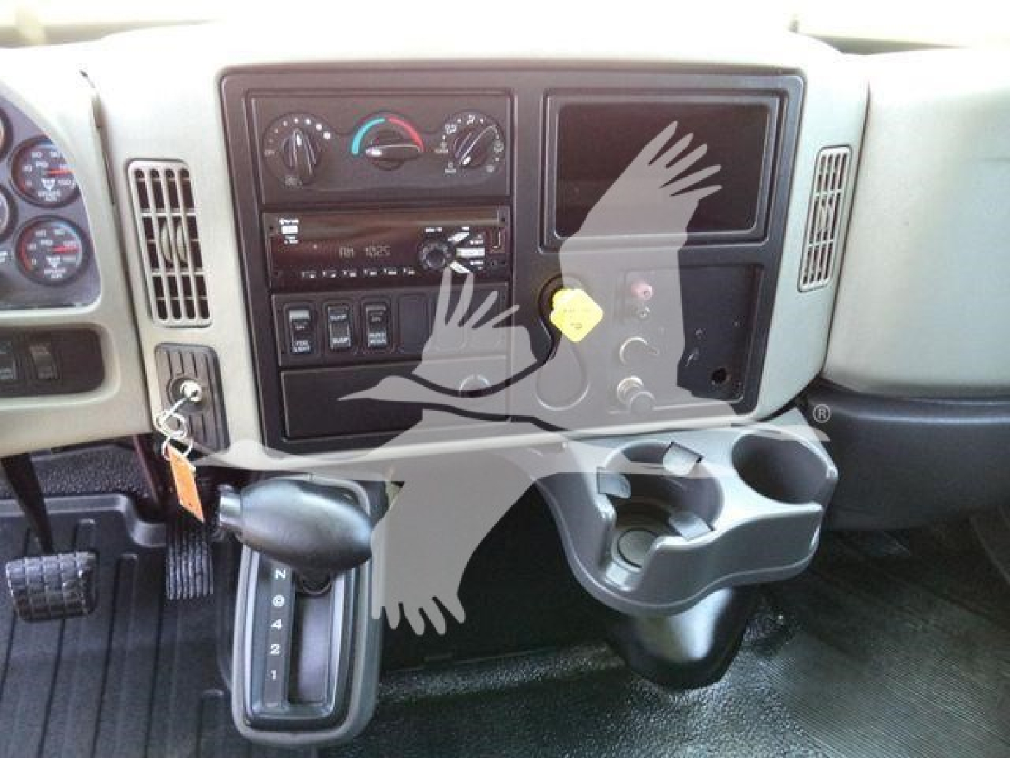 Truck dashboard with climate controls and empty display screen; gear shifter visible; cup holder and storage compartments in view.