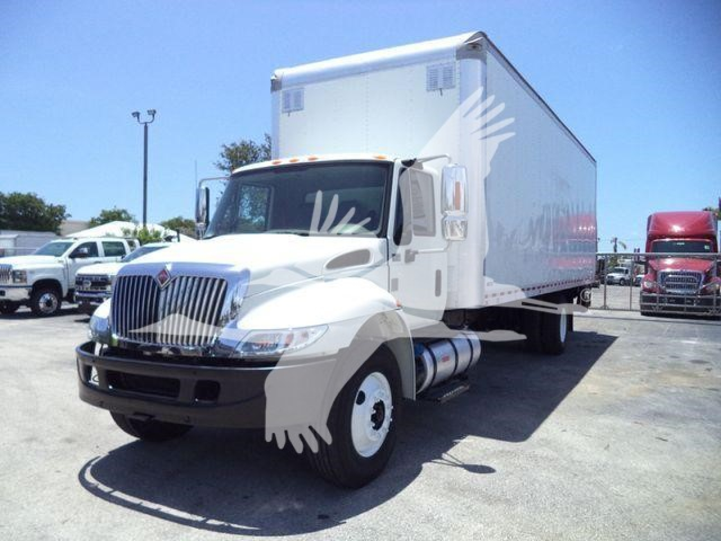Box truck with white cab and cargo box in a dealership lot, International Durastar 4300 model.