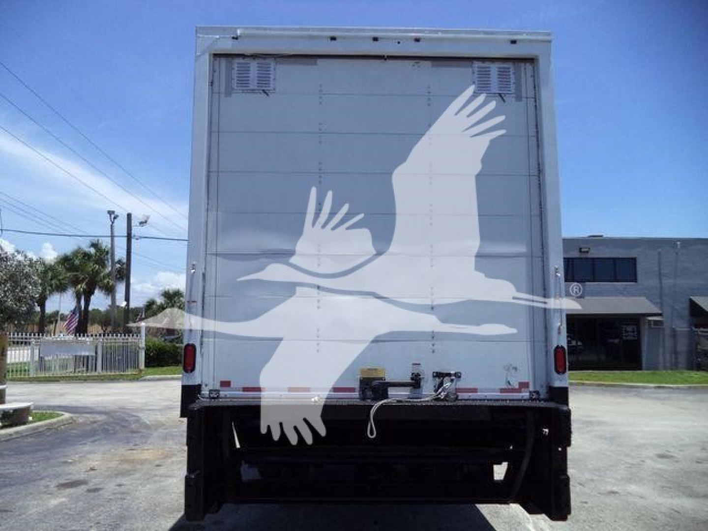 Box truck rear showing large white crane/duck graphic wings on doors, taillights, and bumper visible.