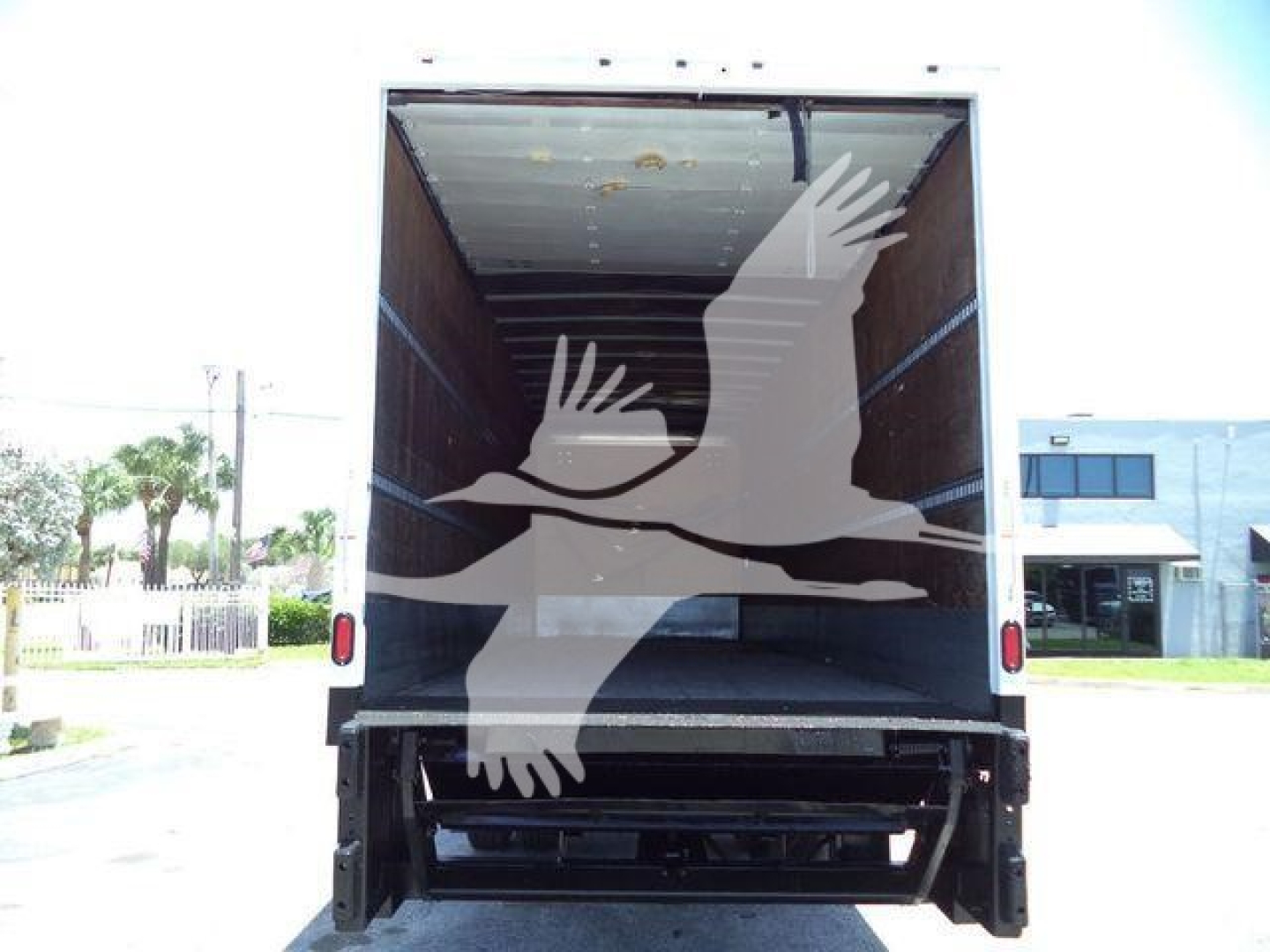Truck box truck rear view with open cargo area and ramp, tailgate and loading area visible.