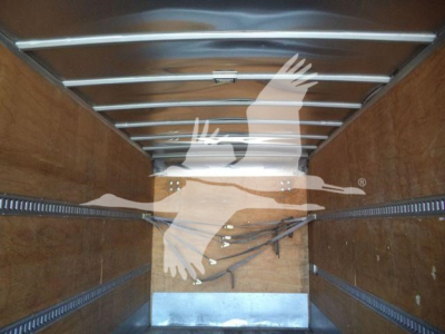 Interior of box truck cargo area showing wooden walls and metal rails along the ceiling.