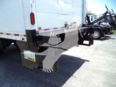 Truck rear showing tailgate, suspension, and bumper area with a MA XON brand plate on the lower left of the trailer.