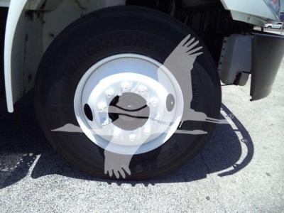 Truck wheel and tire close-up showing Bridgestone tire on International Durastar 4300 front axle.“