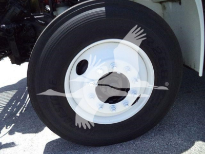 Wheel and tire close-up showing steel wheel on International Durastar 4300 truck, part of front axle assembly.