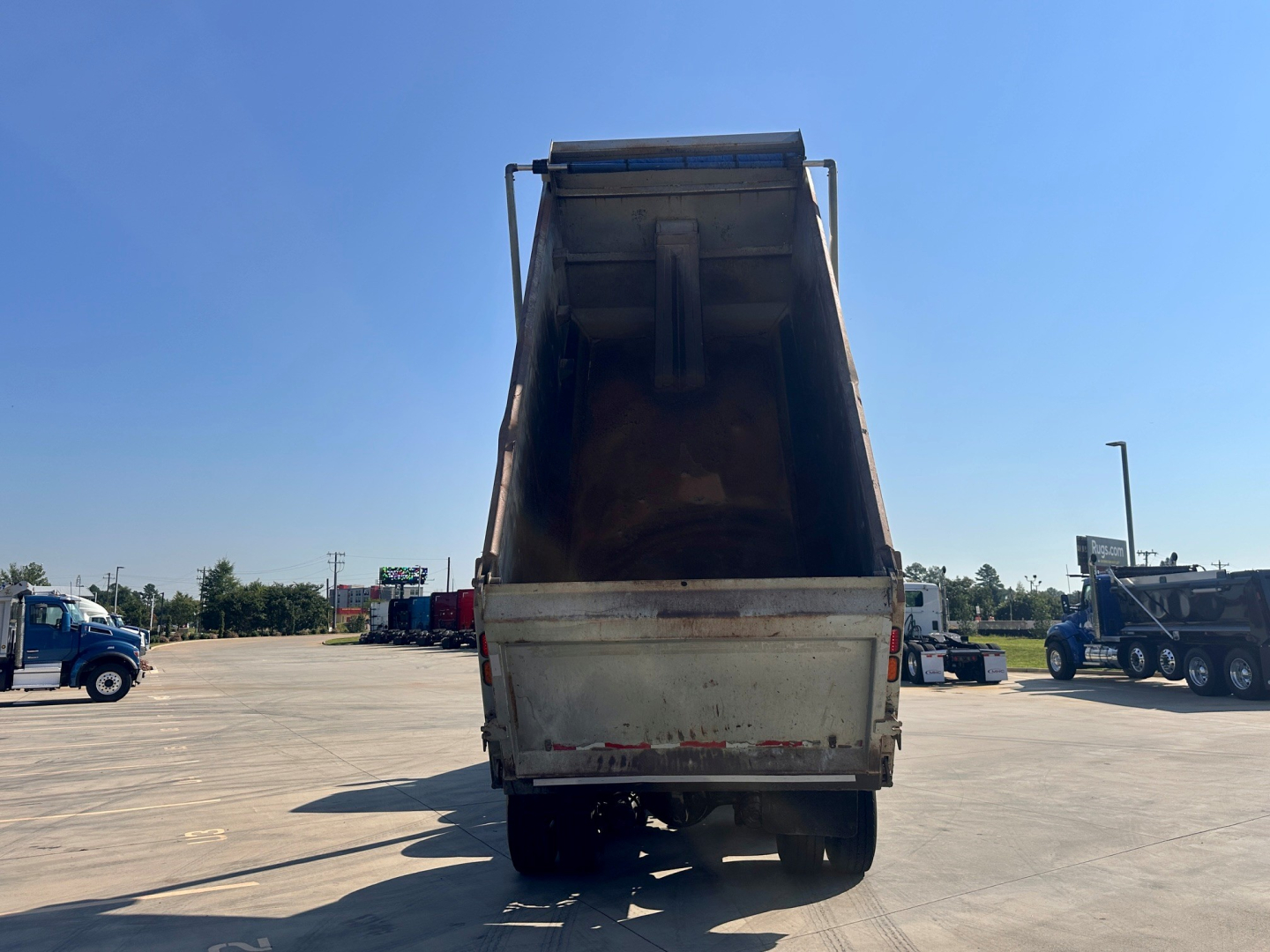 Dump bed of a Kenworth T880 truck in the raised position, rear view showing the empty dump bed and chassis visible.