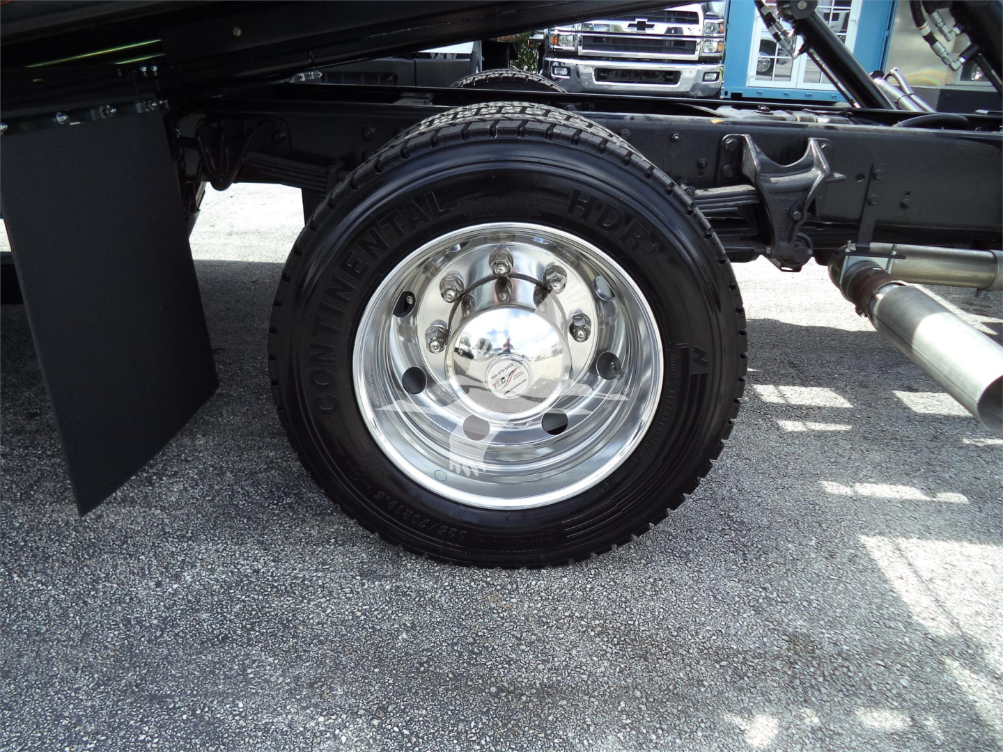 Wheel and tire assembly of a Chevrolet Silverado 6500HD rollback truck showing chrome hub and Continental tire