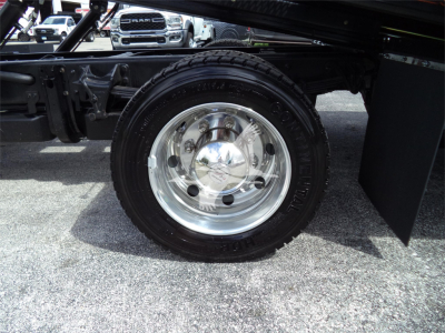Truck wheel and chrome hubcap on Silverado 6500HD chassis showing polished steel wheel and tire profile.