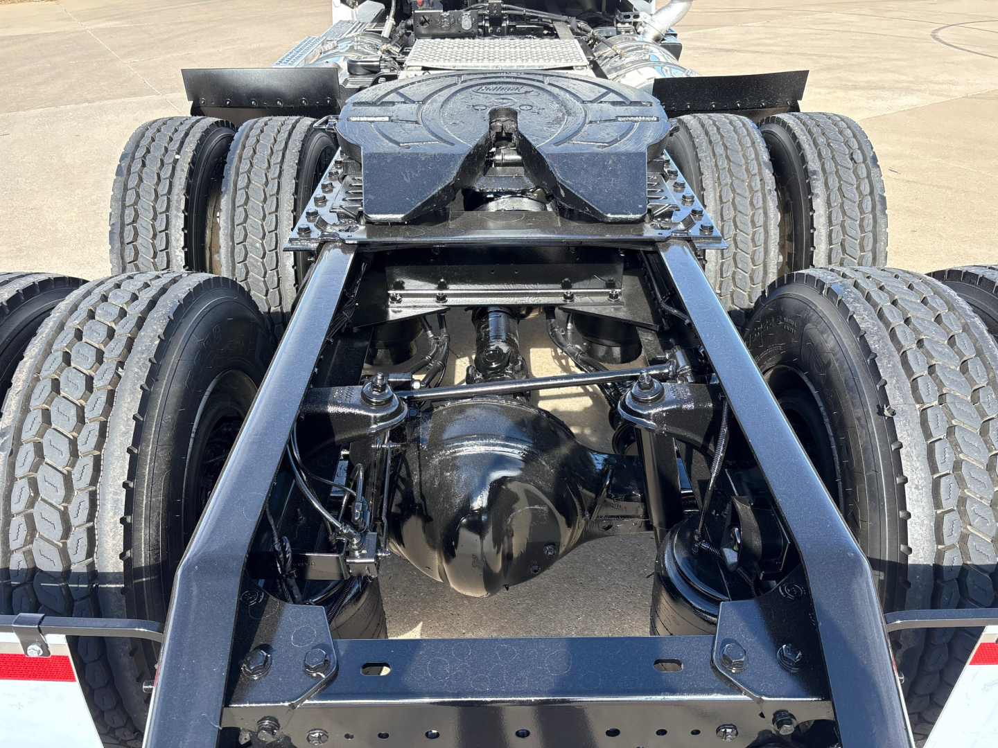 Kenworth T880 chassis view showing rear axle assembly and dual rear sets with tires and frame rails.