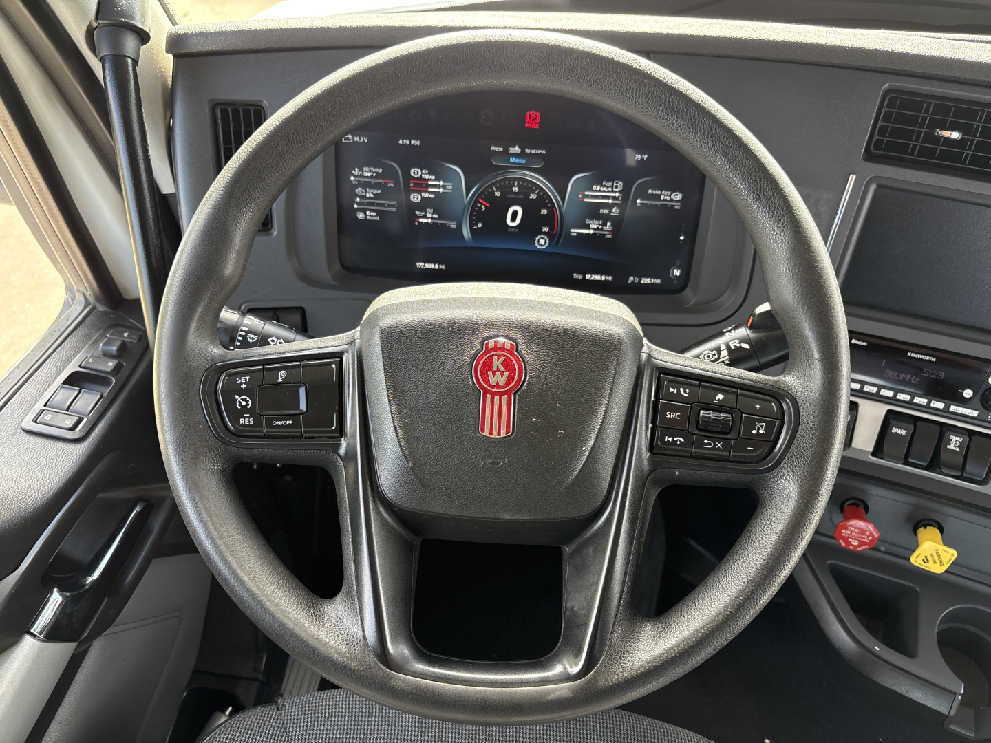 Kenworth T880 steering wheel and instrument cluster in cab showing dashboard display and controls.