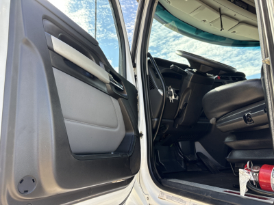 Kenworth T880 truck interior and cab entry showing driver's seat and opened door with steering wheel and dashboard.